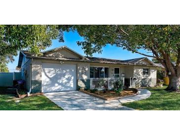 Charming single-story home with lush front yard, driveway, and attached garage at 9436 Glen Moor Ln, Port Richey, FL 34668