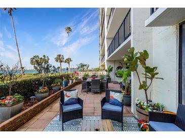 Relaxing patio area with lovely views of the water, potted plants, and comfortable seating at 100 Oakmont Ln # 112, Belleair, FL 33756