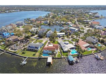 Stunning aerial view of waterfront homes on a peninsula, showcasing pools, docks, and lush landscaping at 119 Carlyle Cir, Palm Harbor, FL 34683