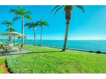 Water view from backyard patio with table and umbrella at 19029 Us Highway 19 N # 29E, Clearwater, FL 33764