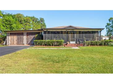 Charming home with a large front yard, screened porch and convenient detached garage at 2102 W Knights Griffin Rd, Plant City, FL 33565