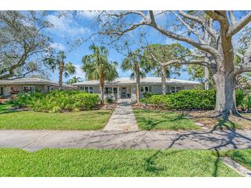 Charming single-story home with a beautifully landscaped front yard, complemented by mature trees and lush greenery at 276 Snell Isle Ne Blvd, St Petersburg, FL 33704