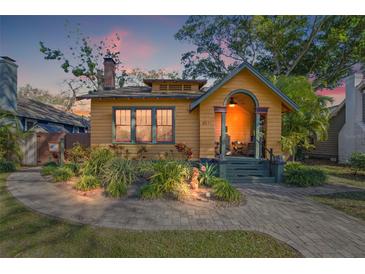 Charming yellow home with a brick walkway, lush landscaping, and inviting front porch at 3235 8Th N Ave, St Petersburg, FL 33713