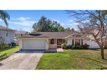 Charming single-Gathering home featuring a well-manicured front yard, driveway and attached two-car garage at 6908 Shady Pl, Tampa, FL 33634