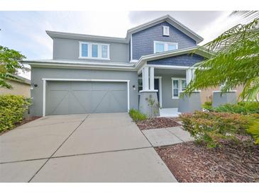 Charming two-story home with a gray exterior, two-car garage and well-maintained landscaping at 7010 Old Benton Dr, Apollo Beach, FL 33572