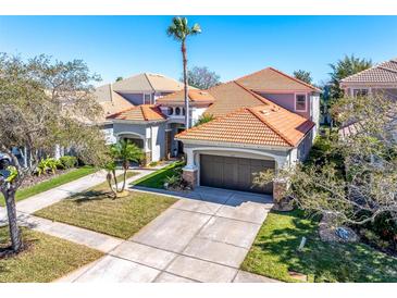 Beautiful home featuring a tile roof, manicured lawn, and two-car garage at 11620 Bristol Chase Dr, Tampa, FL 33626