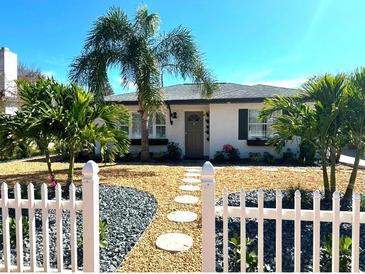 Charming single-story home with a well-manicured front yard and white picket fence at 14066 Marguerite Dr, Madeira Beach, FL 33708