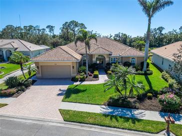 Charming home featuring a beautiful tile roof, well-manicured lawn and inviting curb appeal at 412 Arborview Ln, Venice, FL 34292