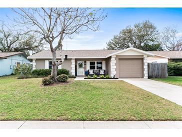 Charming single-story home featuring a well-manicured lawn and a cozy front porch with seating at 12162 Aurora Ct, Largo, FL 33774