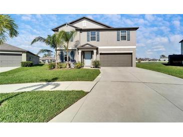 Charming two-story home featuring a well-manicured lawn, a wide driveway, and a two-car garage at 13006 Tidal Flats Loop, Riverview, FL 33579