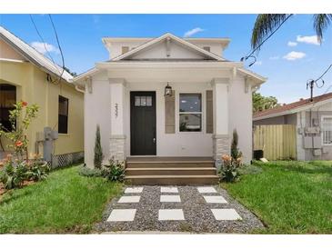 Charming two-story home with landscaped yard, beautiful front door, and welcoming entrance at 2337 W Walnut St, Tampa, FL 33607