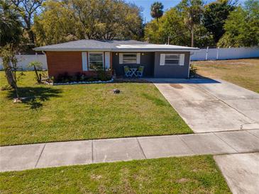 Charming single-story home with well-maintained lawn, updated front door and inviting curb appeal at 27 Park Ave, Tarpon Springs, FL 34689