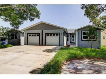 The house has a 2-car garage and is painted in a light color at 14330 Channel Dr, Largo, FL 33774