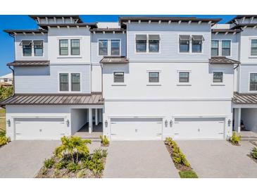 Beautiful three-story townhome features attached garages, well-maintained landscaping, and a contemporary design at 3025 Bermuda Sloop Cir, Ruskin, FL 33570