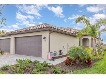 Beautiful single-story home featuring a paver driveway, tile roof, attached two-car garage, and nicely landscaped yard at 5514 Tidal Breeze Cv, Bradenton, FL 34211