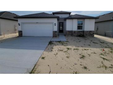 Modern one-story home with an attached garage and stone accents at 12631 Kelly Ann Loop, Brooksville, FL 34613