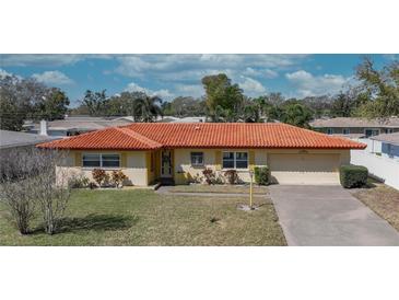 Charming single-story home with terracotta roof, attached garage, well-maintained lawn and mature landscaping at 1450 Highfield Dr, Clearwater, FL 33764