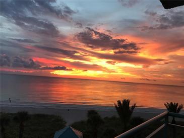 Beautiful sunrise over the ocean with orange and pink colors reflecting on the water and sand at 1520 Gulf Blvd # 805, Clearwater Beach, FL 33767