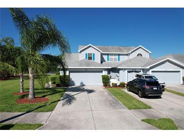 Two-story home featuring a light blue exterior, gray roof, blue shutters, and a spacious driveway with two cars parked at 284 Hemingway Dr, Oldsmar, FL 34677