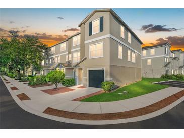 Attractive three-story townhome with a one-car garage surrounded by lush landscaping at 4405 Tuscan Loon Dr, Tampa, FL 33619