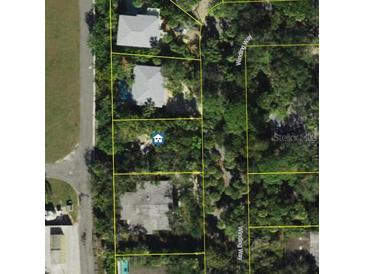 An aerial view of property surrounded by lush trees and a winding road. The view showcases the lot's neighborhood setting at 5218 Winding Way, Sarasota, FL 34242