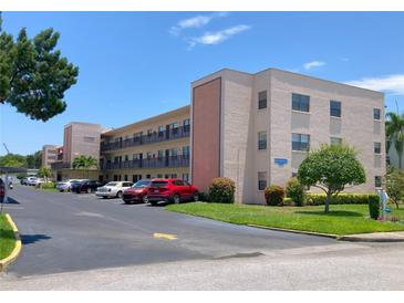 Attractive condo building featuring balconies, assigned parking, and lush landscaping at 5971 Terrace Park N Dr # 310, St Petersburg, FL 33709