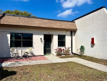 Charming townhome featuring a cozy front patio with bistro set and blossoming flower bed at 1374 Mission Hills Blvd, Clearwater, FL 33759