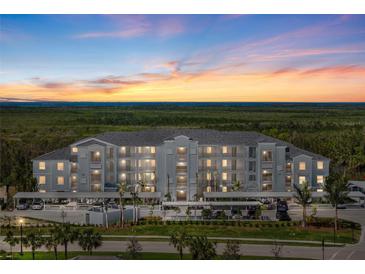 Three-story condo building with sunset, ample parking, and lush landscaping creating an inviting curb appeal at 14191 Heritage Landing Boulevard # 1234, Punta Gorda, FL 33955