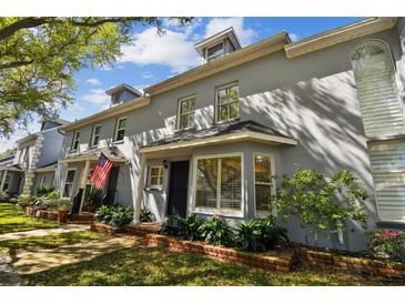 Street view of the townhome featuring beautiful landscaping and a well-maintained lawn at 2515 S Ysabella Ave, Tampa, FL 33629