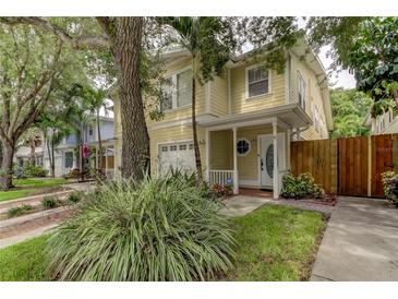 Charming yellow two-story home with a covered front porch and well-maintained landscaping at 402 S Willow Ave # D, Tampa, FL 33606