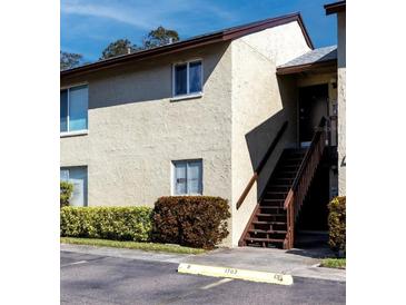 Beige two-story condo building featuring well-maintained landscaping at 4215 E Bay Dr # 1702F, Clearwater, FL 33764
