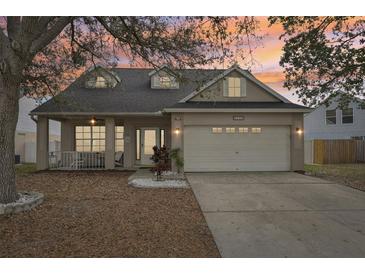 Charming single-Gathering home featuring a spacious front porch and well-manicured lawn at dusk at 4710 69Th E Ct, Palmetto, FL 34221