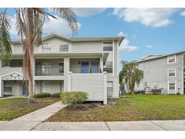 Two-story condo with blue doors and a well-manicured lawn surrounded by mature trees and ample greenery at 7224 E Bank Dr # 206, Tampa, FL 33617