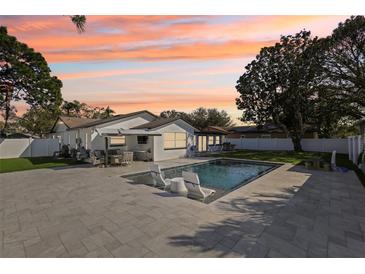 Inviting pool area with modern lounge chairs and beautiful pavers, perfect for relaxing and entertaining outdoors at 8432 Merrimoor Blvd, Seminole, FL 33777