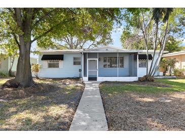 Charming single-story home featuring a screened porch, and a well-maintained front yard with mature trees at 930 40Th Ne Ave, St Petersburg, FL 33703