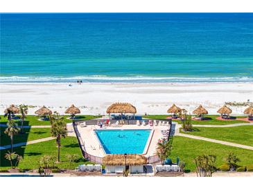 Stunning oceanfront pool with tiki huts and lush landscaping offers a resort-style living experience at 1430 Gulf Blvd # 603, Clearwater Beach, FL 33767