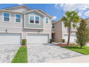 Charming townhome exterior with paver driveway and well-maintained landscaping in a vibrant community at 2334 Audubon Preserve Ln, Lutz, FL 33558