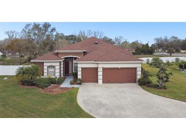Charming single Gathering home boasts a well-manicured lawn, mature landscaping and a two-car garage at 3613 Pendleton Way, Land O Lakes, FL 34639