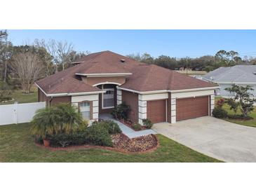 Stunning home featuring a well-manicured lawn, mature landscaping, and a two-car garage at 3613 Pendleton Way, Land O Lakes, FL 34639