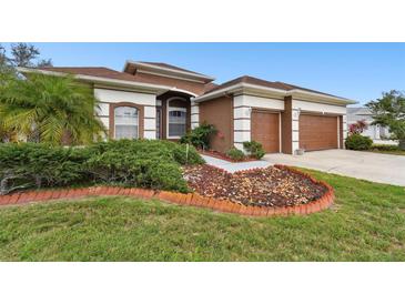 Charming single-story home featuring a well-manicured lawn, rock garden, and a two-car garage at 3613 Pendleton Way, Land O Lakes, FL 34639