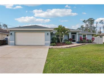 Charming single-story home with a well-manicured lawn, mature landscaping, and an attached two-car garage at 3655 Candia Ave, North Port, FL 34286