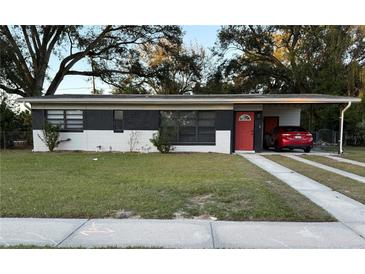 Charming single-story home featuring a well-maintained front yard and covered parking at 4514 Porpoise Dr, Tampa, FL 33617