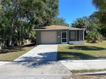 Charming single-story home with a well-maintained lawn, screened in porch and a one-car garage at 505 N Garden Ave, Clearwater, FL 33755