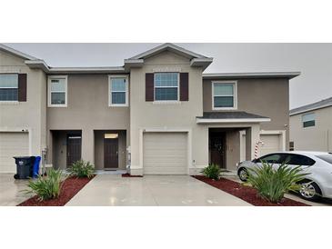 Attractive two-story townhome with attached garage, neutral colors, and manicured landscaping at 518 Glenn Cross Dr, Ruskin, FL 33570