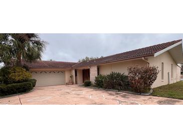 Single story home showcasing a tile roof, two car garage, and mature landscaping at 5360 Windward Way, New Port Richey, FL 34652