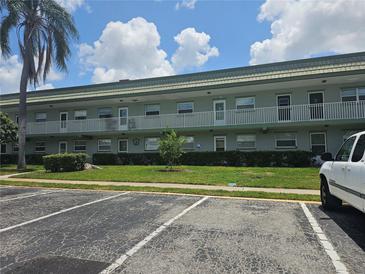 Two-story apartment building featuring a second story balcony, parking and a manicured lawn at 1433 S Belcher Rd # A12, Clearwater, FL 33764