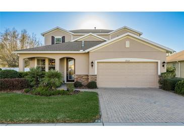 Charming two-story home featuring a manicured lawn and a two-car garage with beautiful stone accents at 19122 Sunset Bay Dr, Land O Lakes, FL 34638
