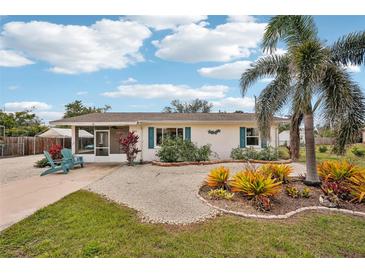 Charming single-story home with a well-maintained yard, palm tree, and bright blue shutters at 829 E 4Th St, Englewood, FL 34223