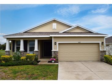 Charming single-Gathering home featuring a well-manicured lawn and a two-car garage, creating a welcoming curb appeal at 8438 Wheat Stone Dr, Zephyrhills, FL 33540