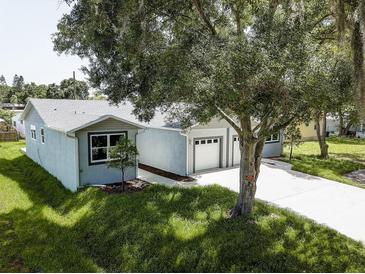 Charming single-story home with well-maintained lawn, attached two-car garage, and mature landscaping at 14334 Channel Dr, Largo, FL 33774